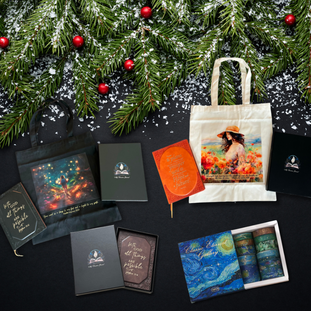My Devotion Journal Christmas Gift Bundle featuring a black Psalm 119 tote bag, cream Proverbs 31 tote bag, hardcover prayer journals in multiple colors, and a set of Van Gogh inspired washi tapes arranged on a festive holiday background with evergreen branches and snow.
