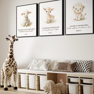 A cozy and charming nursery featuring three adorable animal-themed wall art prints with scripture verses. The artwork includes a lamb with John 1:36, a deer with Psalm 42:1, and a lion with Proverbs 28:1. Each animal is beautifully illustrated in soft, pastel tones, perfect for a children's space. The room is decorated with plush toys, including a large stuffed giraffe and a fluffy dog, along with a storage bench filled with pillows and organized bins underneath. The serene and faith-filled environment creates a peaceful space for little ones to grow.
